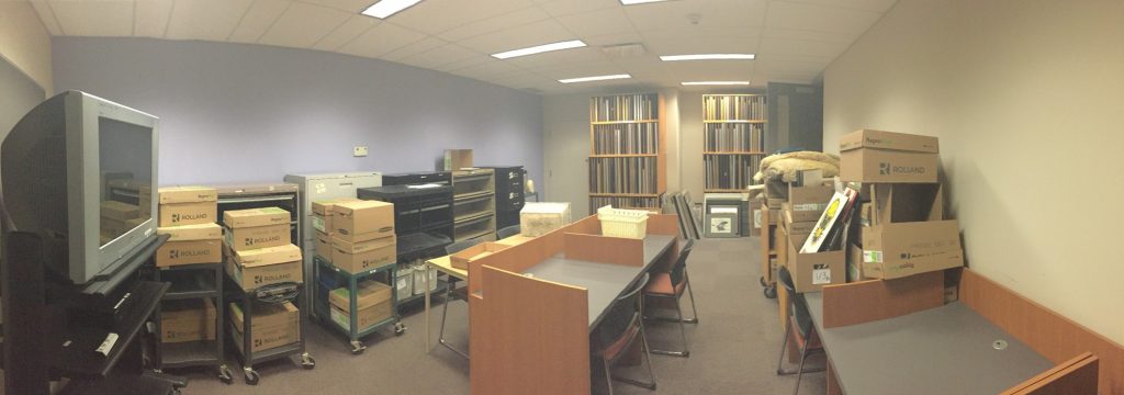 Panorama of a storage room filled with boxes and a large TV