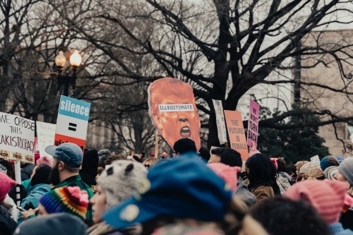 People in a crowd holding signs and protesting