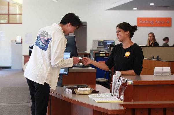 Student assistant helping a student at the service point in Stauffer Library
