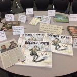 Secret Path by Gord Downie featured prominently on a table with newspaper clippings