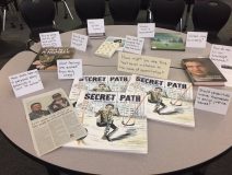 Secret Path By Gord Downie Featured Prominently On A Table With Newspaper Clippings