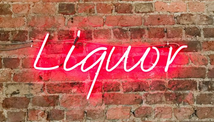 Pink Neon Sign On Brick Wall Says Liquor