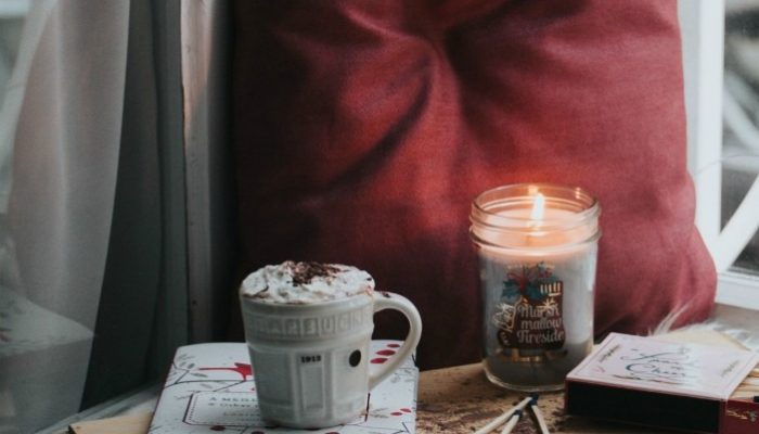 A Photo Of A Pillow, With A Candle And A Cup Of Chocolate
