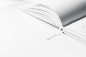 An open white book against a white background.