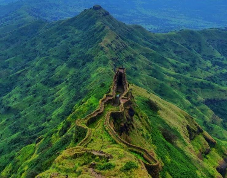 An aerial shot of a mountain top with a walled pathway