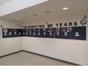 a picture of the corner of a room. Pages with pictures are aligned under the heading "Celebrating 100 years"