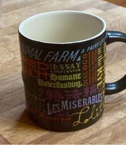 A photo of a coffee mug with colourful text.